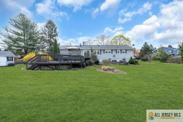 rear view of property featuring stairs, a yard, and a deck