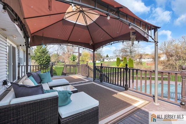 view of patio / terrace with a gazebo, outdoor lounge area, a deck, and a fenced in pool