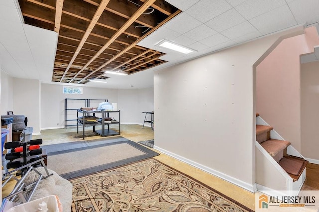 basement featuring stairway and baseboards