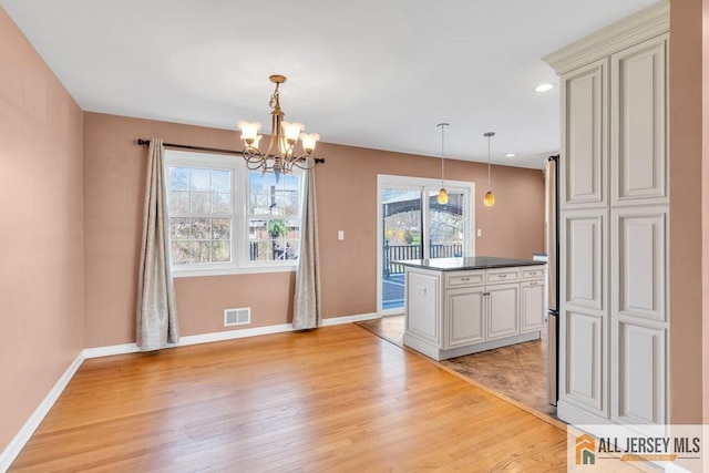 kitchen with baseboards, light wood-style flooring, and visible vents