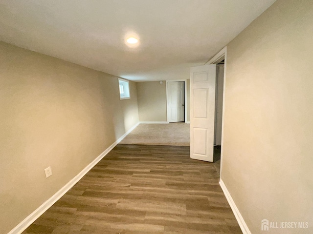 hallway with dark wood-type flooring and baseboards