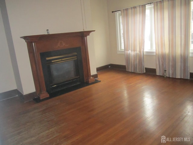 458 S Barclay St, Perth Amboy, NJ 08861 - unfurnished living room featuring wood finished floors and a glass covered fireplace