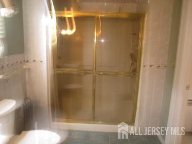 458 S Barclay St, Perth Amboy, NJ 08861 - bathroom featuring tile walls, a stall shower, and tile patterned floors