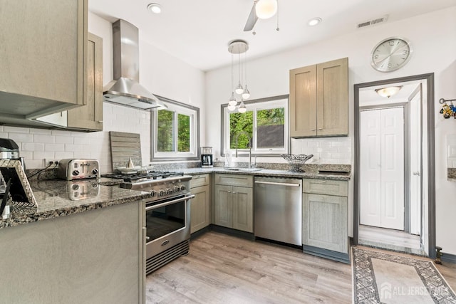 229 Greenbrook Rd, Green Brook, NJ 08812 - kitchen featuring appliances with stainless steel finishes, wall chimney range hood, ceiling fan, dark stone counters, and decorative backsplash