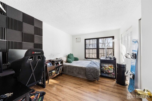 bedroom with a textured ceiling and wood finished floors