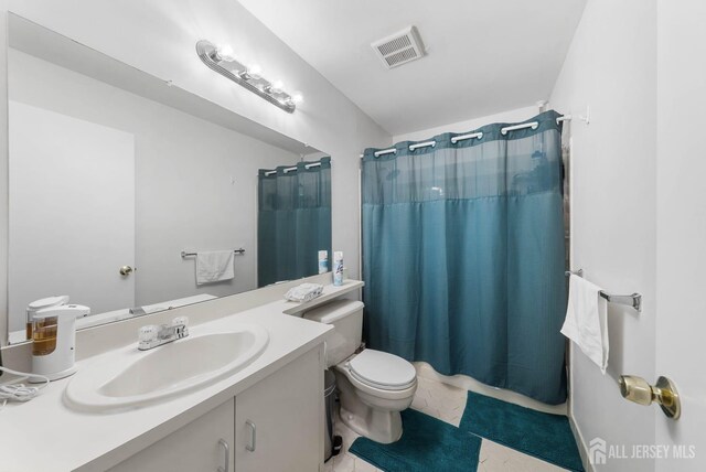 full bathroom featuring visible vents, vanity, and toilet