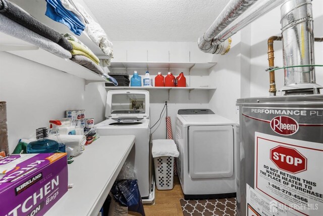 washroom with laundry area, dark wood-style flooring, a textured ceiling, and washing machine and clothes dryer