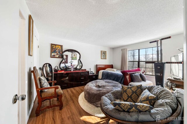 bedroom with a textured ceiling and wood finished floors