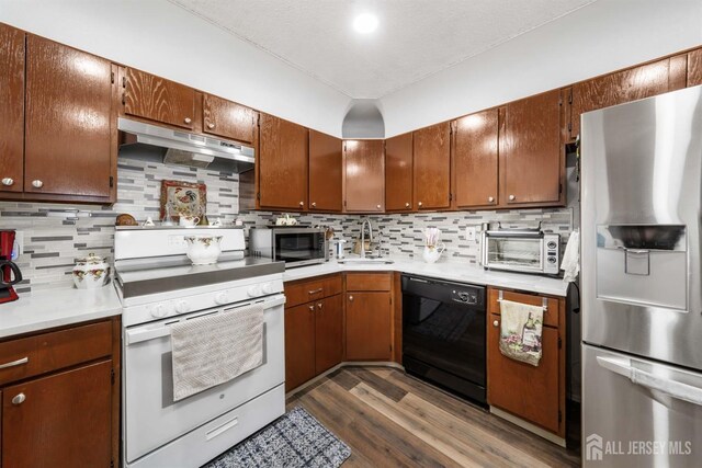 kitchen featuring light countertops, appliances with stainless steel finishes, a sink, and under cabinet range hood