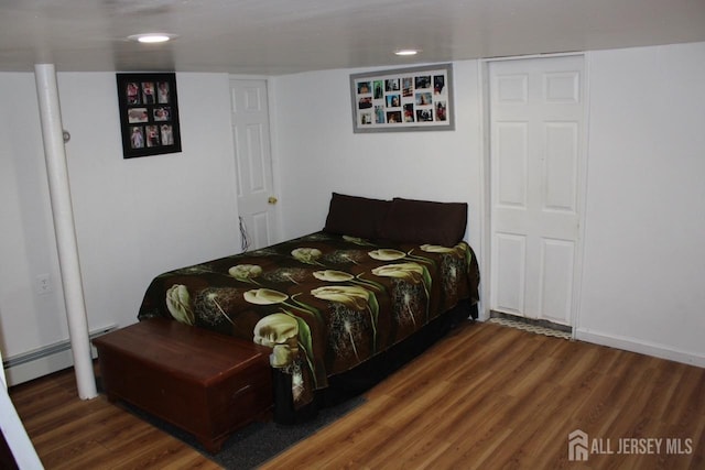 bedroom featuring baseboard heating and dark wood-type flooring