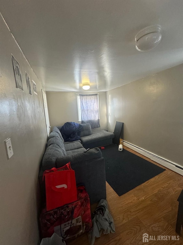 living room featuring a baseboard heating unit and hardwood / wood-style flooring