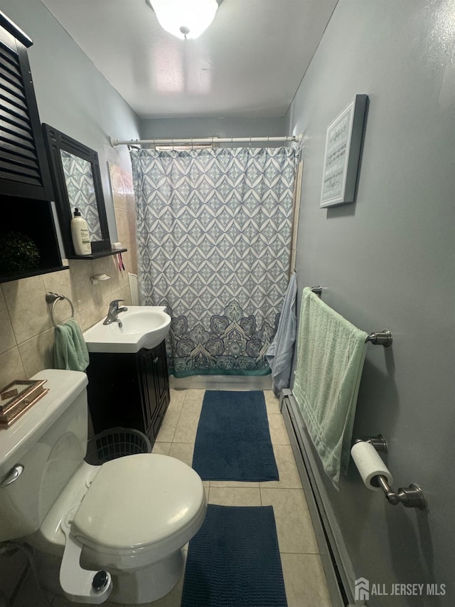 bathroom with a shower with shower curtain, tile patterned floors, vanity, baseboard heating, and toilet