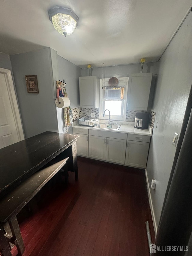 kitchen with dark hardwood / wood-style floors, sink, white cabinetry, and backsplash