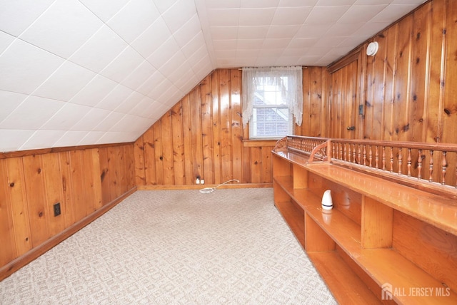 bonus room with carpet floors, lofted ceiling, and wooden walls