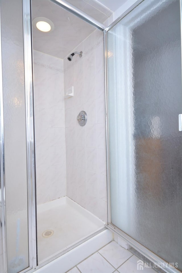 bathroom with a stall shower and tile patterned flooring