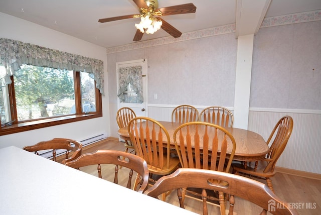 dining room featuring wainscoting, wood finished floors, and a ceiling fan