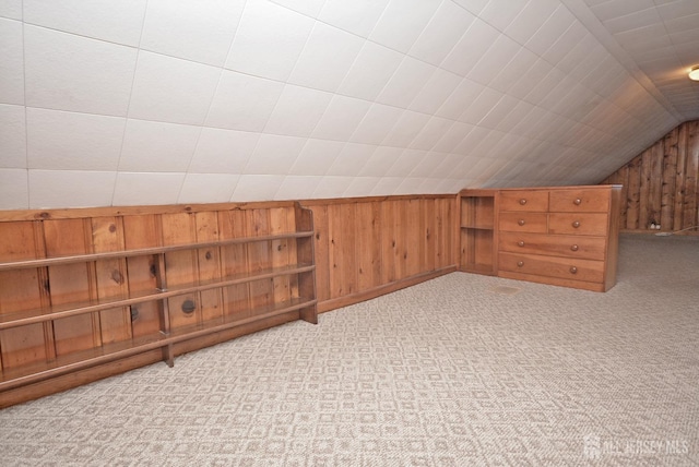 additional living space with lofted ceiling, wood walls, and carpet floors