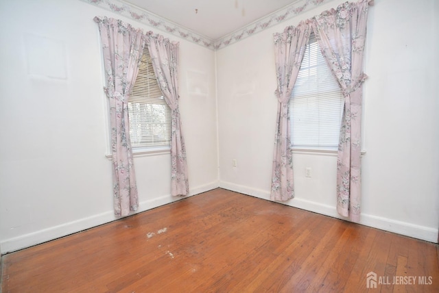 unfurnished room with hardwood / wood-style flooring and baseboards