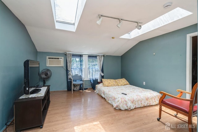 571 Greenbrook Rd, North Plainfield, NJ 07063 - bedroom featuring a skylight, a wall mounted air conditioner, vaulted ceiling, wood finished floors, and track lighting
