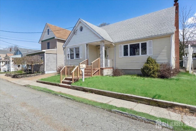 399 Highland St, South Amboy, NJ 08879 - view of front of home featuring a front yard, a garage, a chimney, and roof with shingles