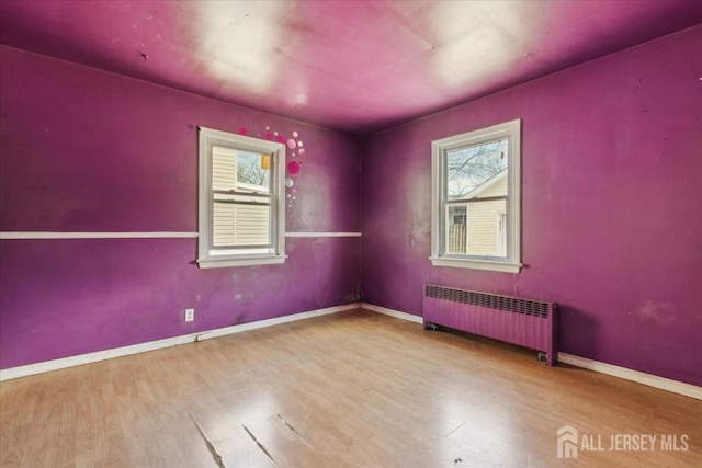 399 Highland St, South Amboy, NJ 08879 - empty room featuring radiator heating unit, healthy amount of natural light, and wood finished floors