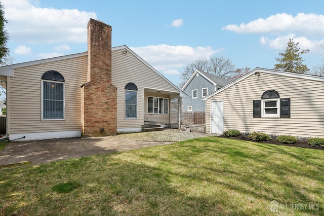 rear view of property featuring a patio and a chimney
