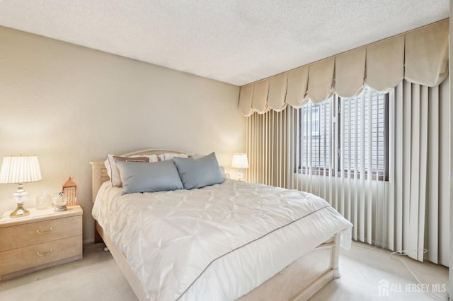 bedroom with light colored carpet and a textured ceiling