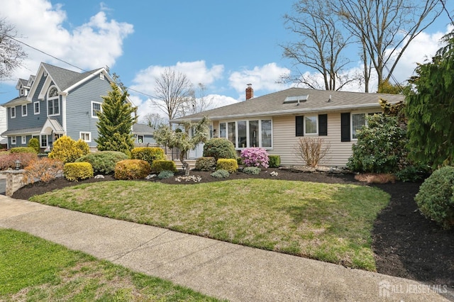 view of front of house with a chimney and a front yard