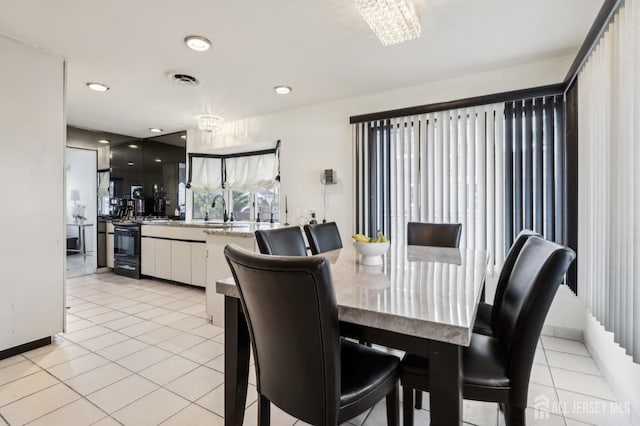 dining area featuring light tile patterned floors, recessed lighting, baseboards, and a chandelier