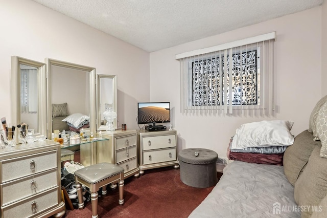 bedroom featuring dark carpet and a textured ceiling