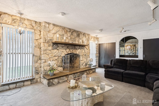 living room featuring carpet, a textured ceiling, plenty of natural light, and a chandelier