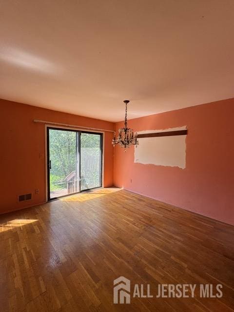 165 Penn Ct, Old Bridge, NJ 07747 - unfurnished room with a chandelier and wood finished floors