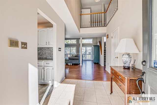 foyer featuring light tile patterned floors and a high ceiling