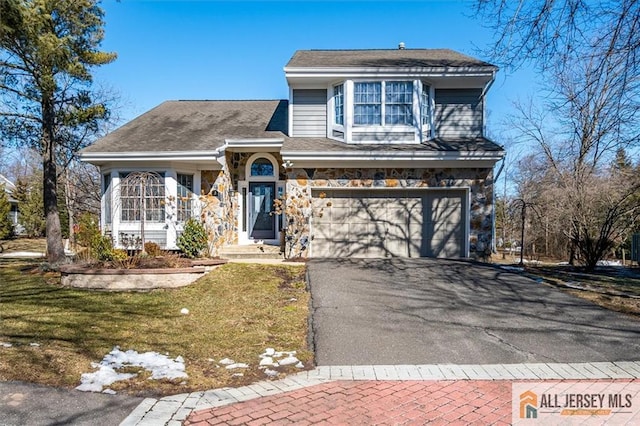 view of front of property featuring aphalt driveway, stone siding, a front yard, and an attached garage