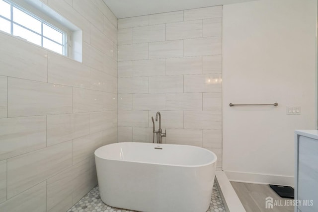 bathroom with tile walls, tile patterned flooring, and a bathtub