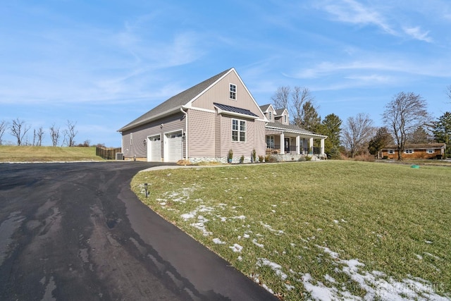 view of front facade featuring a porch, a garage, and a front yard