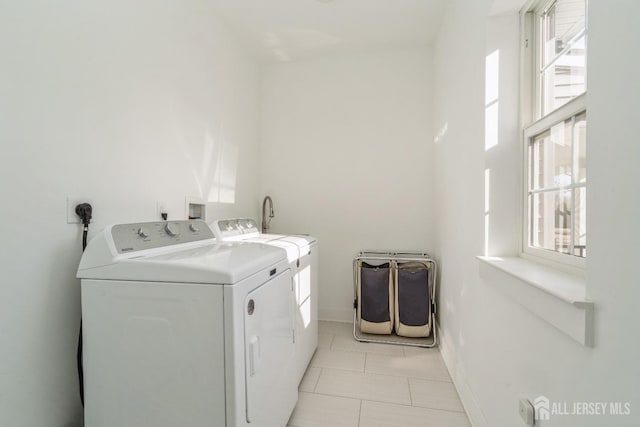 washroom with light tile patterned floors and washer and clothes dryer