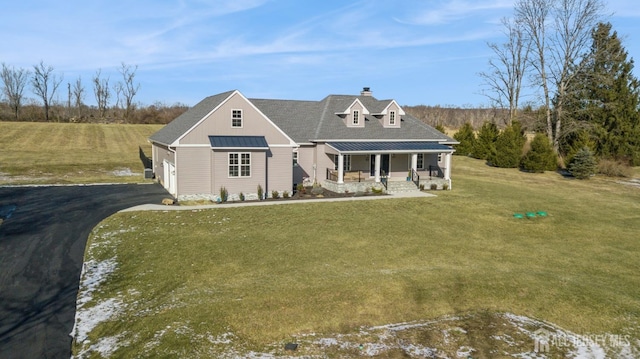 new england style home with a porch and a front lawn