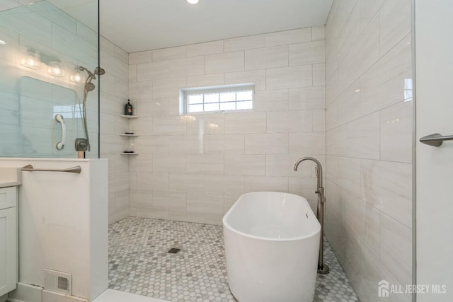 bathroom with vanity, tile patterned flooring, independent shower and bath, and tile walls