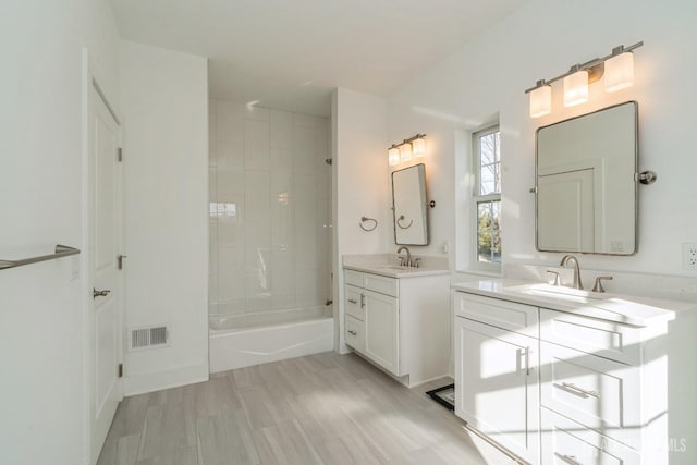 bathroom featuring vanity and tiled shower / bath