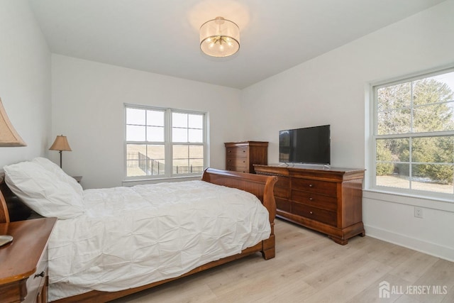 bedroom featuring multiple windows and light wood-type flooring