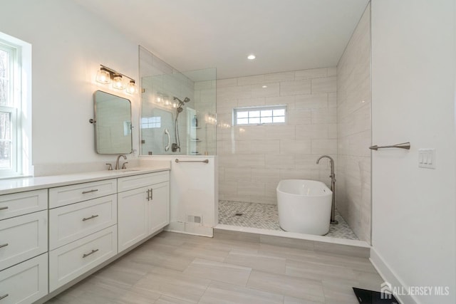 bathroom with vanity, tile patterned floors, and plus walk in shower