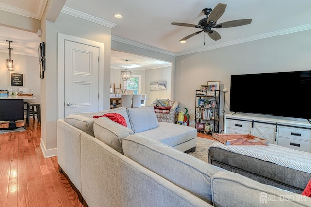 living area with light wood-type flooring, recessed lighting, a ceiling fan, ornamental molding, and baseboards