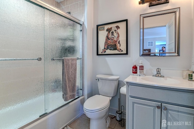 bathroom with vanity, combined bath / shower with glass door, toilet, and tile patterned flooring