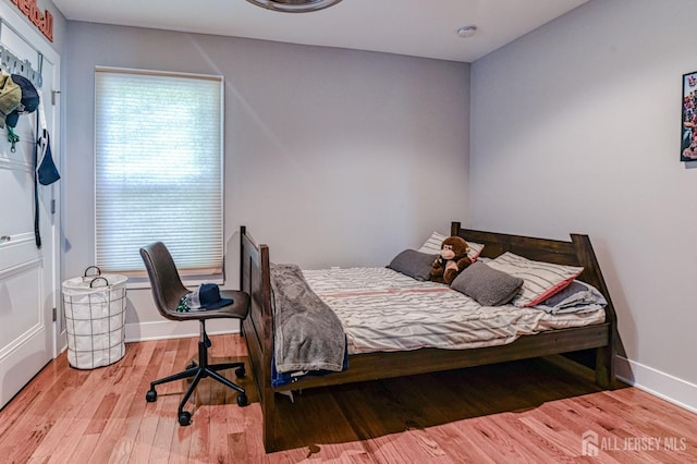 bedroom featuring wood finished floors and baseboards