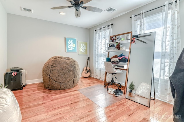sitting room with a ceiling fan, wood finished floors, and baseboards