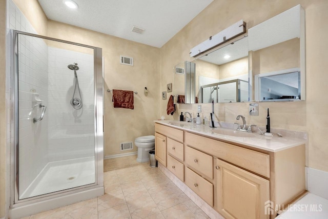 bathroom featuring tile patterned floors, a shower with shower door, vanity, and toilet