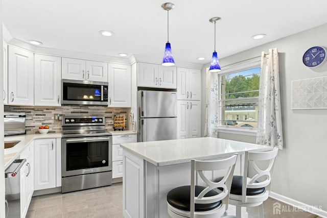 675 Bound Brook Rd Unit C0019, Dunellen, NJ 08812 - kitchen featuring stainless steel appliances, white cabinetry, tasteful backsplash, recessed lighting, and hanging light fixtures