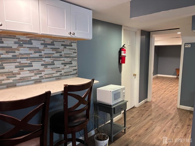 220 S Washington Ave, Dunellen, NJ 08812 - bar with white microwave, wood finished floors, and backsplash