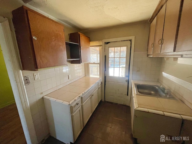 170 Rutgers St, New Brunswick, NJ 08901 - kitchen with tile countertops, a sink, decorative backsplash, open shelves, and a textured ceiling